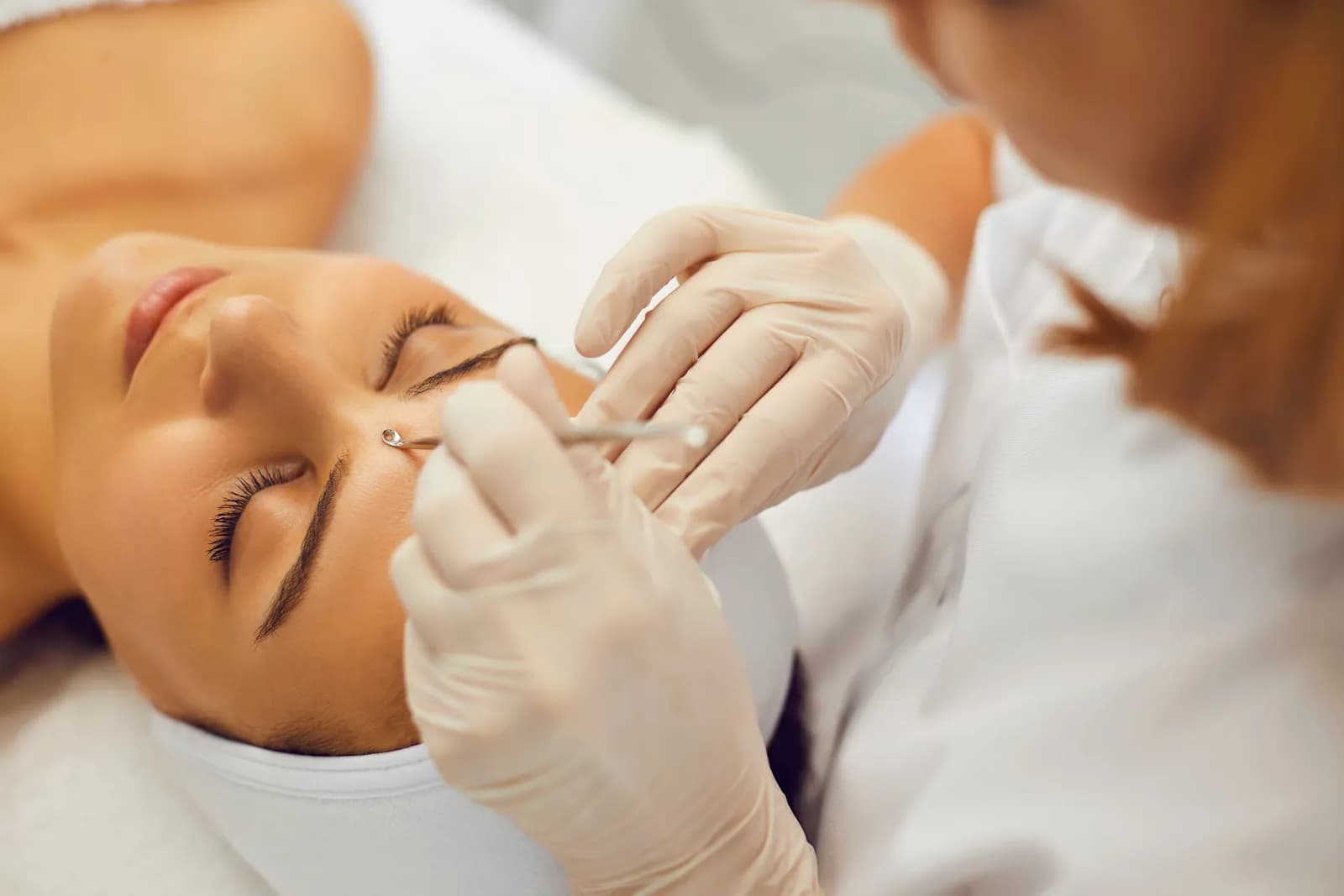 Woman getting acne facial with deep extraction to clear pores and reduce breakouts