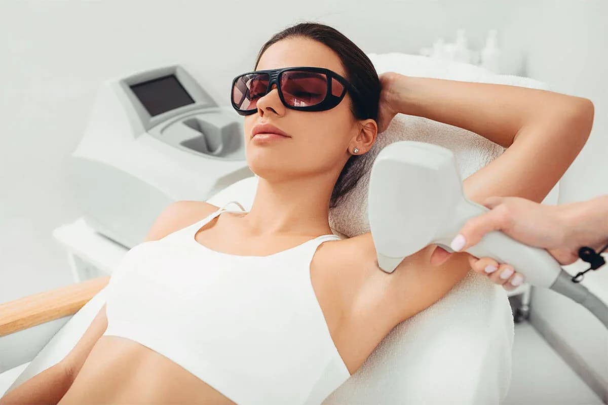 Woman receiving laser hair removal treatment on underarms for smooth, hair-free skin